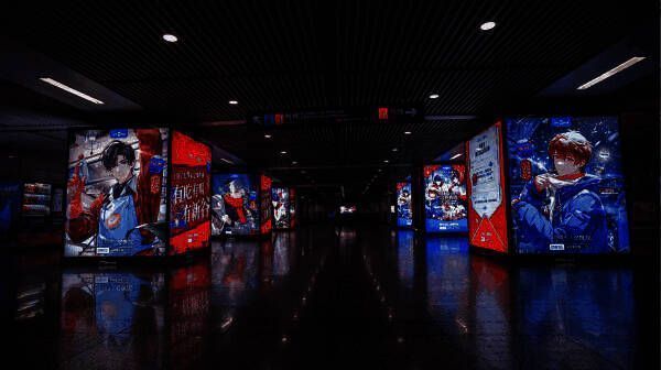 上海徐家汇地铁站内游戏角色大屏广告，行人驻足观看