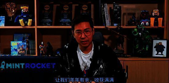 黄载皓在办公室手持麦克风录制视频，身后是《潜水员戴夫》开发团队的工作墙