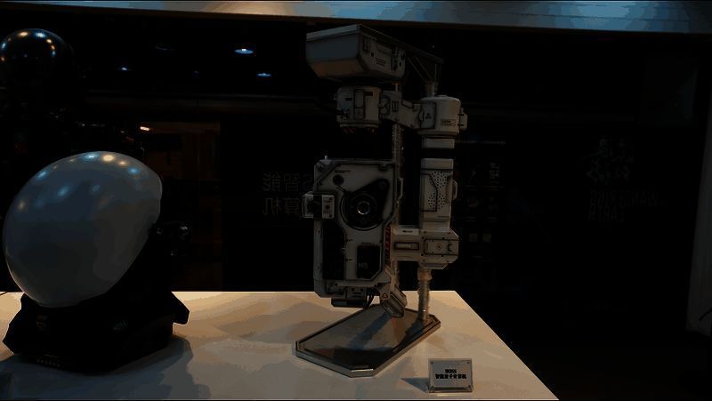 观众试穿《流浪地球》同款外骨骼装备，神情兴奋，背景为MOSS全息投影