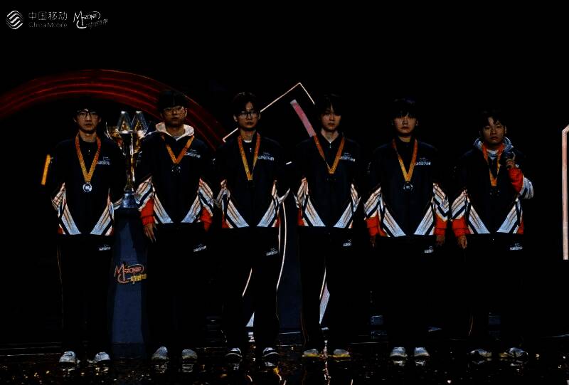 电竞选手在比赛现场激烈对战，屏幕显示战队对战画面，观众席座无虚席