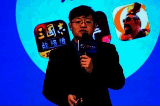 唐贾军在论坛上发表演讲，身后大屏幕展示《2024中国游戏产业未成年人保护报告》核心数据图表