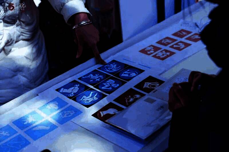 玩家正在参与‘赏雪拓画’手工活动，专注地在纸上拓印雪花图案