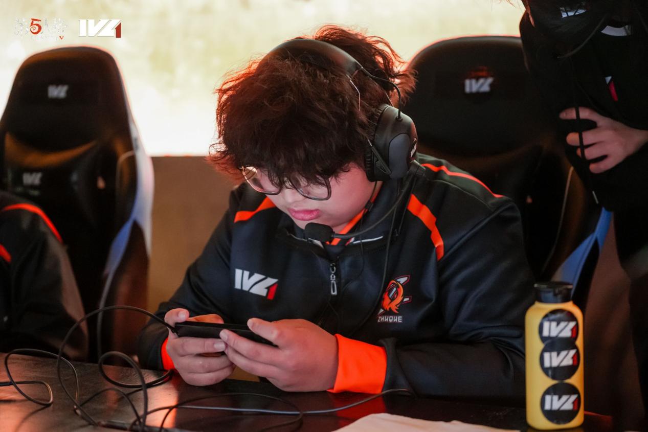 FPX.ZQ_Alpaca选手正面特写照,身着战队黑色队服,神情专注沉静,背景为电竞舞台灯光与《第五人格》赛事LOGO